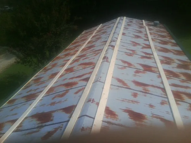 Rusted metal roof panels with new wood purlins before replacement — Storm Damage Roof Repair in East Millsboro by Roofing Brothers